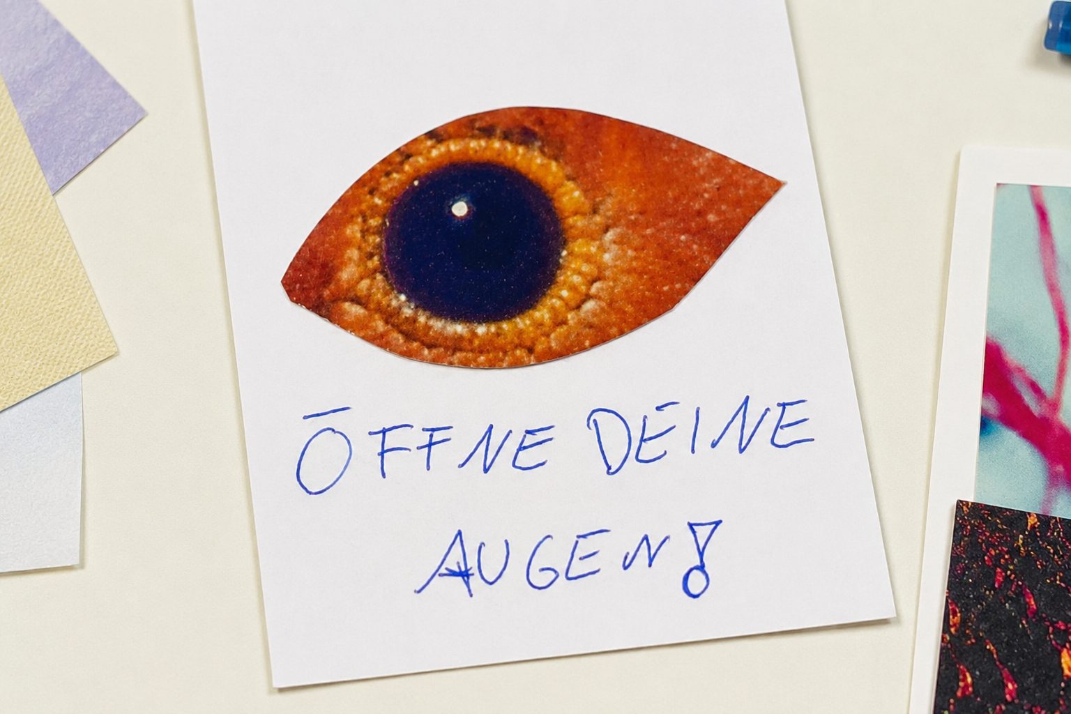 A journal page with a painted amber-and-blue eye and the words Öffne deine Augen — open your eyes