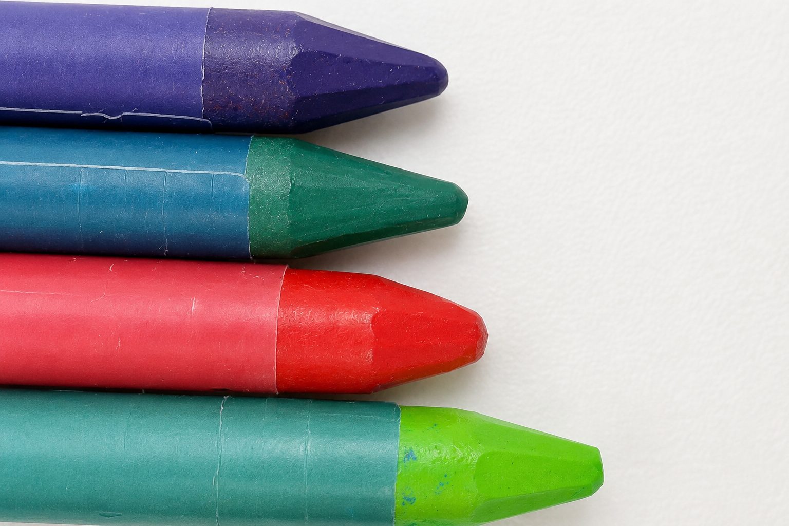 A row of oil pastels — teal, green, red, pink